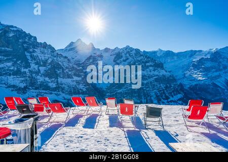 Grindelwald-FIRST, SVIZZERA - 15 GENNAIO 2020: Sedie a sdraio rosse vuote a Schreckfeld sulla Prima montagna Foto Stock