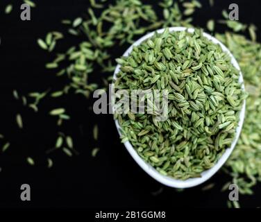 semi di finocchio su un bordo nero Foto Stock