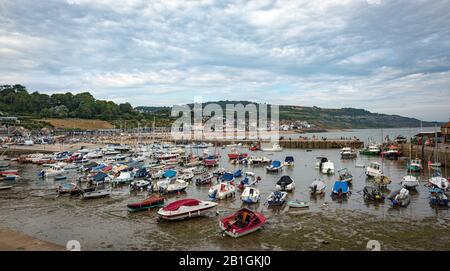 Barche locali sulla zona sabbiosa intertidale a bassa marea in legis ryme, Inghilterra meridionale Foto Stock