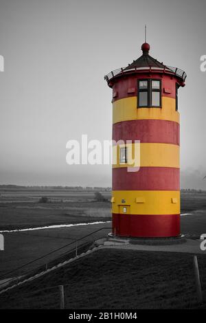 Faro di Pilsum su una diga sulla costa del Mare del Nord, Frisia orientale Foto Stock