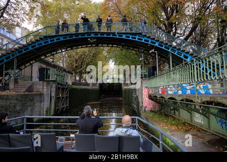 Giro in barca sotto un ponte di ferro verso una serratura nel Canal Saint Martin.Paris.France Foto Stock