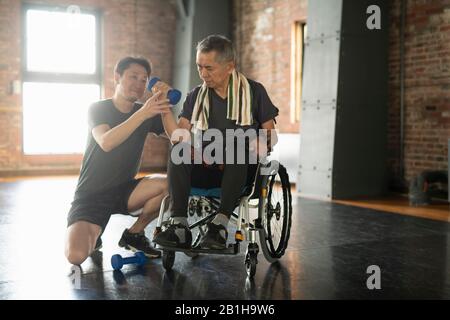 Uomo anziano in fase di riabilitazione con istruttore Foto Stock