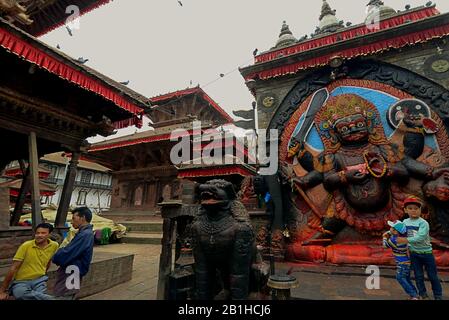 Persone che hanno tempo libero vicino all'immagine di Kala Bhairav (Lord Shiva) a Kathmandu Durbar Square, Kathmandu, Nepal. Foto Stock