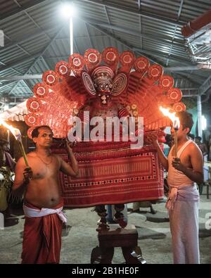 Theyyam interprete, come dio vivente, danze una forma rituale popolare di culto nel Kerala del Nord, vicino a Kannur, India. Foto Stock