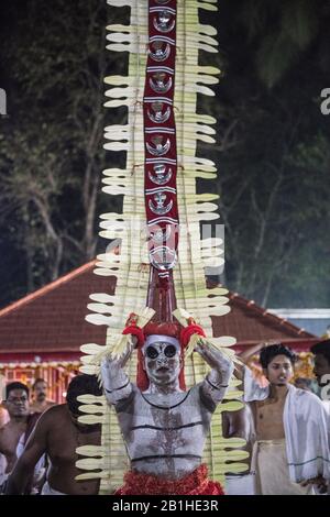 Theyyam interprete, come dio vivente, danze una forma rituale popolare di culto nel Kerala del Nord, vicino a Kannur, India. Foto Stock