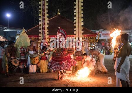 Theyyam interprete, come dio vivente, danze una forma rituale popolare di culto nel Kerala del Nord, vicino a Kannur, India. Foto Stock