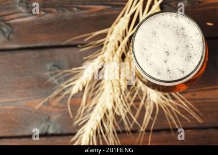 Birra di vetro su sfondo di legno. Foto creativa. Foto Stock