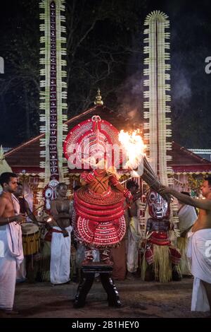 Theyyam interprete, come dio vivente, danze una forma rituale popolare di culto nel Kerala del Nord, vicino a Kannur, India. Foto Stock