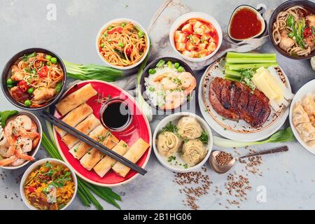 Piatti cinesi assortiti su sfondo grigio. Cucina asiatica. Vista dall'alto Foto Stock