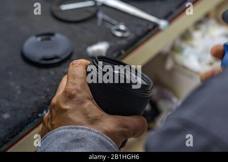Foto di primo piano della tenuta delle mani e della lente della fotocamera per la pulizia Foto Stock