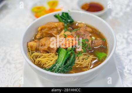 Deliziosa zuppa di noodle di manzo brasato in stile cinese su sfondo bianco Foto Stock