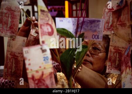 Donna che impiccano i soldi durante la celebrazione per l'apertura del Buddha più grande in America Latina Foto Stock