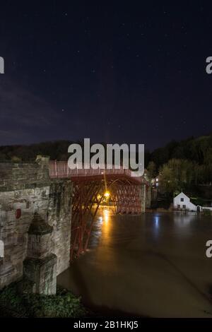 Ironbridge, Regno Unito. 26th Feb 2020. 2-3am al mattino, una settimana dal record precedente e Ironbridge sta ancora una volta sperimentando livelli di inondazione record. Mentre si trova all'ombra del famoso ponte, dopo il quale la città prende il nome, le difese delle inondazioni stanno battendo per tenere indietro i livelli del fiume in aumento, la lunga esposizione notturna crea una serena immagine millstagno del punto di riferimento storico stesso. Credito: Paul Bunch/Alamy Live News Foto Stock