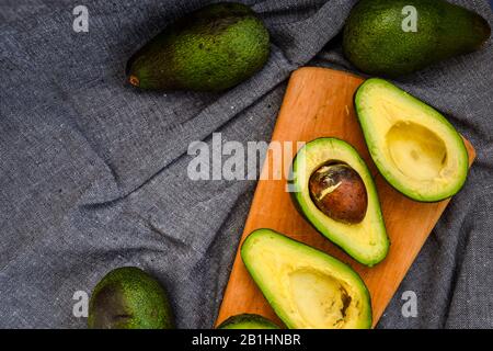 Avocado su una tavola di legno. Concetto di cibo sano. Vista dall'alto, Copia spazio Foto Stock