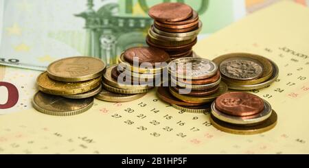 stack di monete sul calendario, closeup shot, per sfondo finanziario Foto Stock