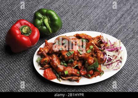 Pollo al drago. Strisce di pollo marinate, fritte e saltate in salsa piccante e piccante Foto Stock