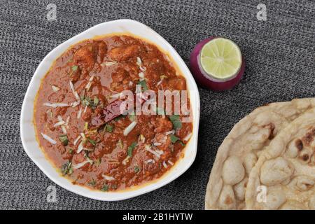 Curry di pollo servito con roti o pane indiano Foto Stock