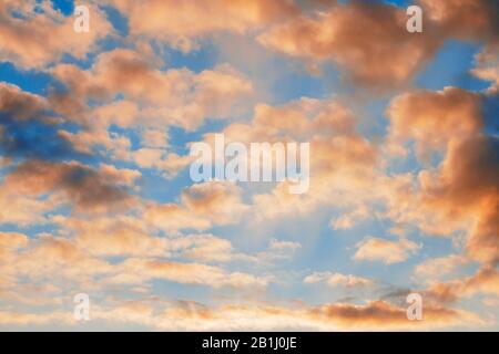 Giallo cumulo brillante rosso grigio arancione drammatico nuvole su un cielo blu al tramonto. Foto Stock