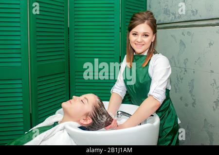 Parrucchiere lavaggio dei capelli della donna nel lavandino nel salone di bellezza. Foto Stock