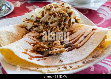 Frittelle con panna montata, noci e sciroppo d'acero in Italia. Foto Stock