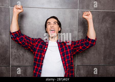Sì! Giovane uomo felice trionfante con i pugni sollevati Foto Stock