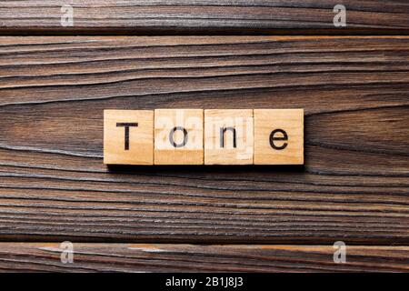 Tono parola scritta sul blocco di legno. tono testo sul tavolo in legno per il desing, concetto. Foto Stock