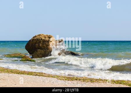 Le onde si infrangono su pietre e rocce che fanno un sacco di spruzzi. Splendida vista sul mare. Foto Stock