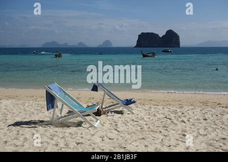 Isola di Koh Ngai (Koh Hai) Spiaggia orientale vicino a Koh Lanta nella provincia di Krabi in Thailandia con spiaggia di sabbia bianca, due lettini blu spiaggia, mare turchese Foto Stock