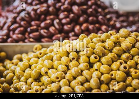 Un mucchio di olive verdi siriane lucide, piene di olio. Nessun kernel. Sfondo sfocato. Stile arabo. Il Vecchio Mercato Di Mahane Yehuda, Gerusalemme. Foto Stock