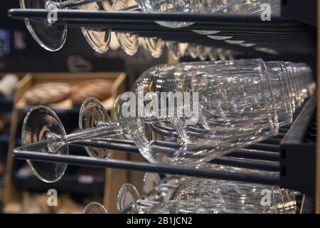 Bicchieri e bottiglie su un rack nella cantina. Alcool Foto Stock