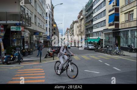 9 Settembre 2014 Svizzera Ginevra. Una giovane ragazza in un casco protettivo sta cavalcando una bicicletta su una strada a Ginevra. Foto Stock