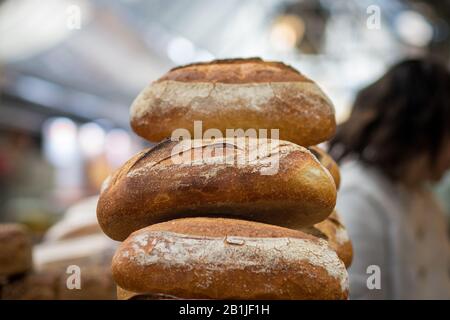 Un mucchio di pane fresco fatto di farina intera. Sfondo croccante e sfocato. Il Mercato, Gerusalemme. Foto Stock