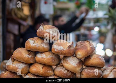 Un mucchio di pane fresco fatto di farina intera. Sfondo croccante e sfocato. Il Mercato, Gerusalemme. Foto Stock