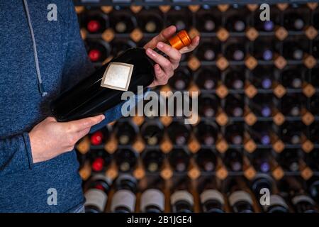 l'uomo presenta una bottiglia di vino raro con chiusura a vite al degustatore nella sala spettacolo Foto Stock