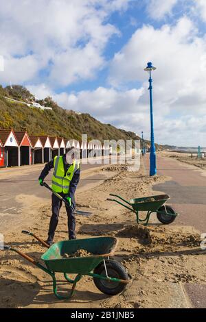 Bournemouth, Dorset, Regno Unito. 26th Feb 2020. Il consigliere Lewis Allison, si blocca e dà ai ranger del lungomare una mano per liberare la sabbia dal lungomare, soffiata dai recenti forti venti e Storm Dennis. L'Assessore Allison è Assessore al lavoro per Boscombe West e Titolare del portafoglio, membro del Gabinetto, per il Turismo, il tempo libero e le Comunità presso il Consiglio BCP (Bournemouth, Christchurch e Poole). Credit: Carolyn Jenkins/Alamy Live News Foto Stock