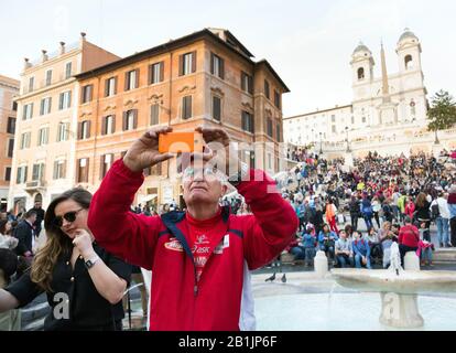 Senior MAN scatta una foto selfie alla Fontana della Barcaccia di Roma Foto Stock