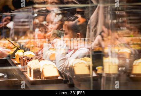 Shanghai, CINA - 11 GENNAIO 2020: La ragazza aspecifica vorrebbe mangiare il pane al Roastero Starbucks di Shanghai è il più grande Starbucks del mondo. Foto Stock