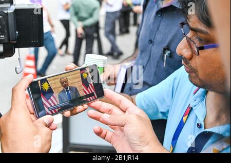 Kuala Lumpur, Malesia. 26th Feb, 2020. I giornalisti guardano una trasmissione in diretta di un discorso televisivo del primo ministro malese ad interim Mahathir Mohamad al di fuori del Palazzo Nazionale di Kuala Lumpur, Malesia, 26 febbraio 2020. Il primo ministro provvisorio malese Mahathir Mohamad ha rotto il suo silenzio mercoledì dalle dimissioni, dicendo che era disposto a tornare al potere se c'era un sostegno sufficiente per lui a istituire un governo non partigiano che dà la priorità solo all'interesse del paese. Credito: Zhu Wei/Xinhua/Alamy Live News Foto Stock