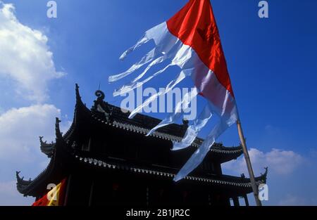 Suzhou Cina. Porta Panmen, silhouette contro un cielo blu, bandiera tradizionale in primo piano. Foto Stock