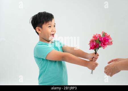 Carino ragazzino che tiene un bouquet di fiori.Mothers Day. Giornata Internazionale Della Donna. Ritratto di un ragazzino felice su sfondo bianco. Molla. Foto Stock