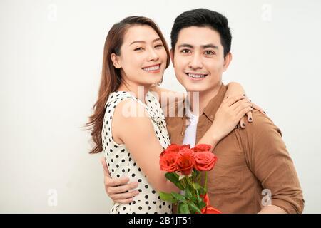 Immagine che mostra felice coppia abbracciando con i fiori Foto Stock