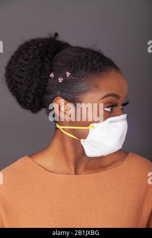 Giovane donna che indossa una maschera protettiva per il viso Foto Stock