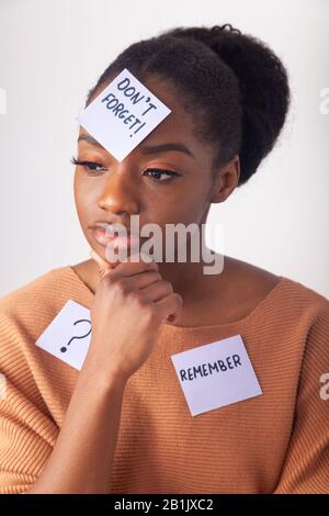 Giovane donna nera con una nota adesiva sulla fronte dicendo non dimenticare. Foto Stock