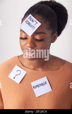 Giovane donna nera con una nota adesiva sulla fronte dicendo non dimenticare. Foto Stock