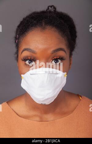 Giovane donna che indossa una maschera protettiva per il viso Foto Stock