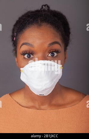 Giovane donna che indossa una maschera protettiva per il viso Foto Stock