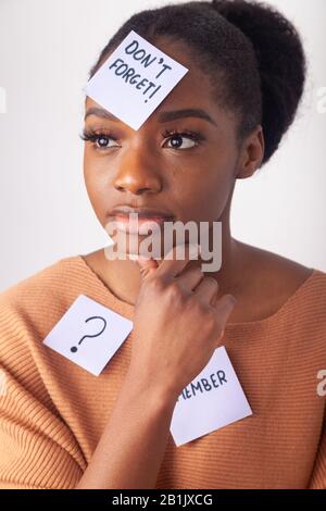 Giovane donna nera con una nota adesiva sulla fronte dicendo non dimenticare. Foto Stock