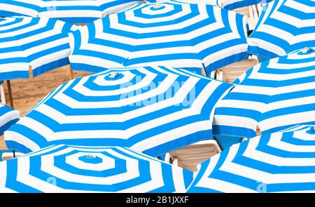 Motivo a strisce di ombrelloni blu e bianco. Astratto sfondo estivo foto scattata su una spiaggia in giornata di sole Foto Stock