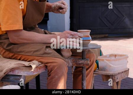 Mani di un vasaio fa una pentola di creta su ruota di vasai. Ceramica e artigianato concetto. Foto Stock