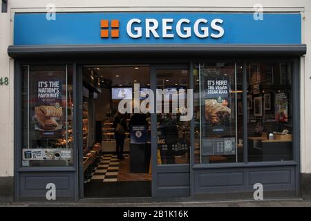 Greggs negozio di prodotti da forno davanti, esterno, pubblicità Vegan bistecca cuocere e vegan salsiccia rotolo su High Street, Epsom, Surrey, UK - 2020 Foto Stock